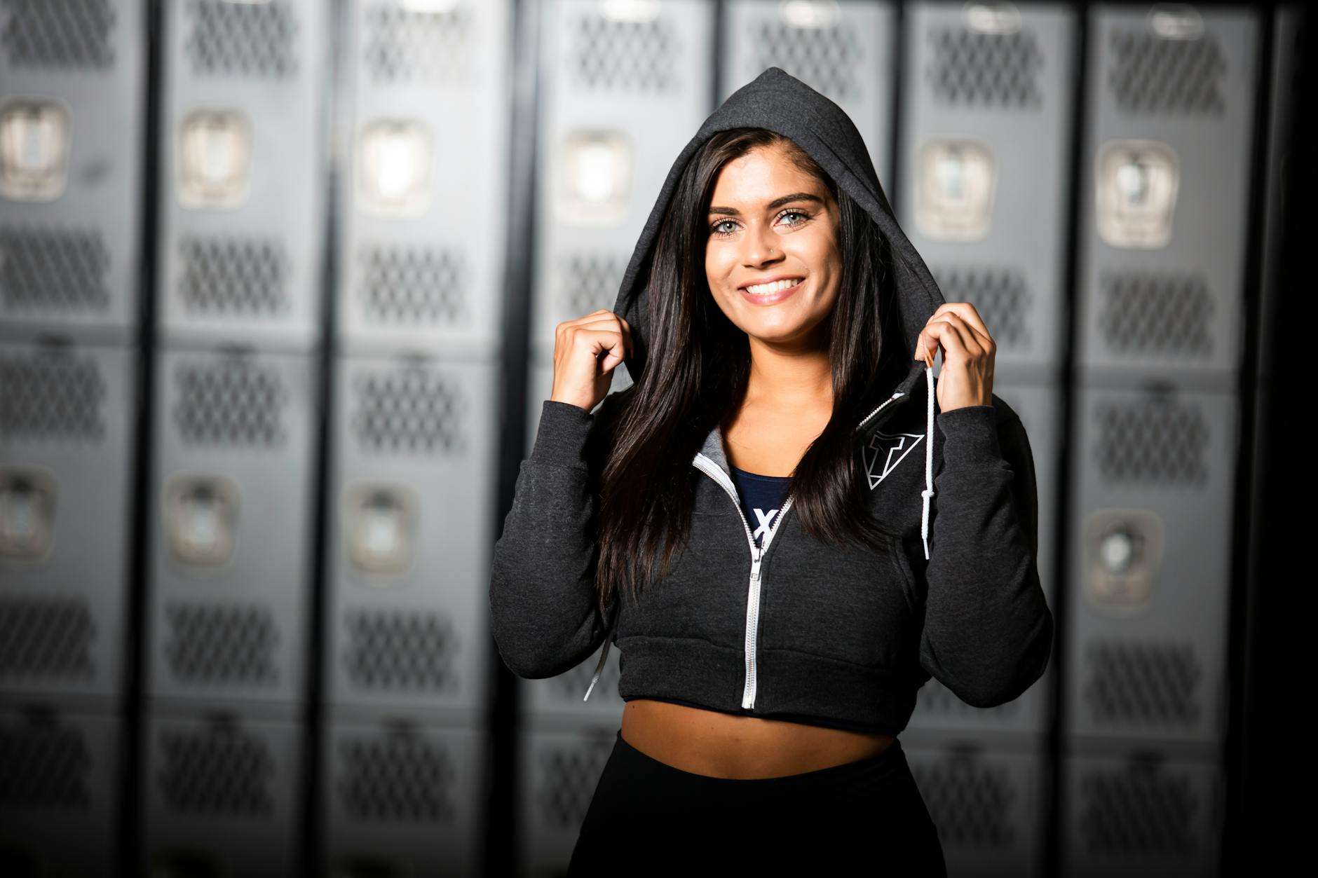 Smiling confident woman in sportswear looking towards the camera, against a soft background