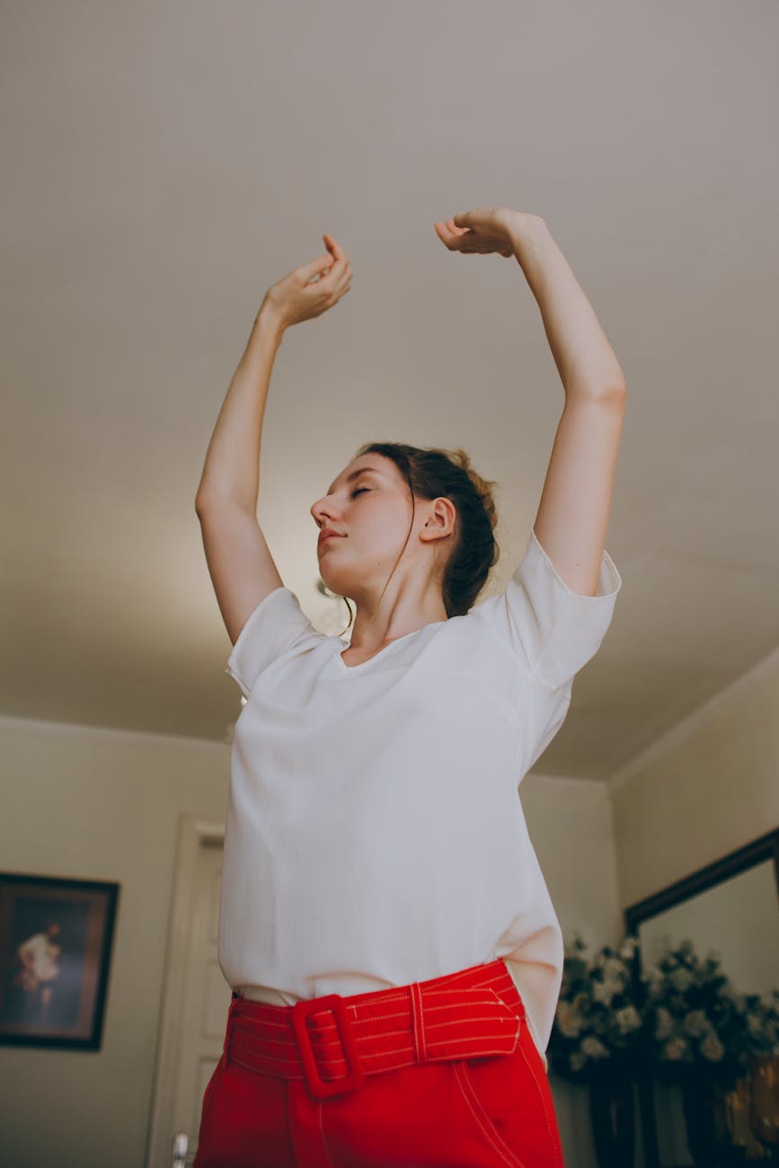 Woman stretching her back gracefully in a brightly lit room with minimalist decor